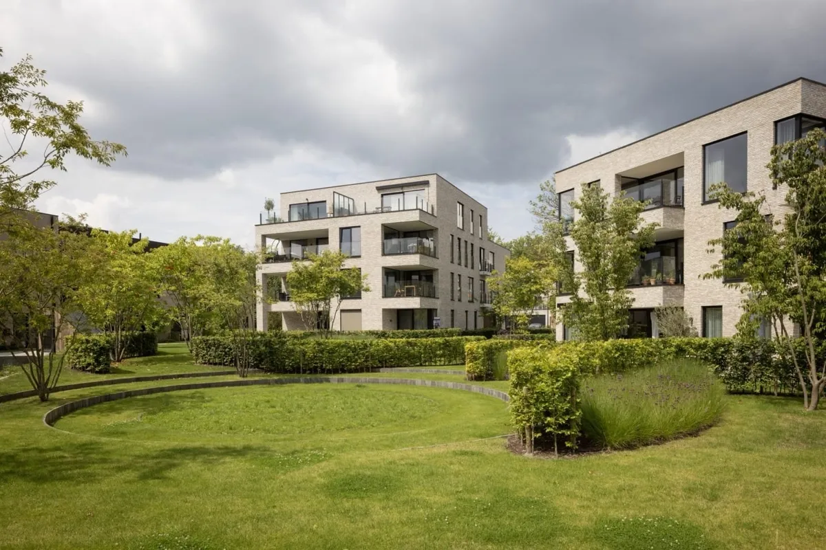 Landscaped communal garden and brick apartment buildings at Maple Garden, a two-minute walk from UZ Gent